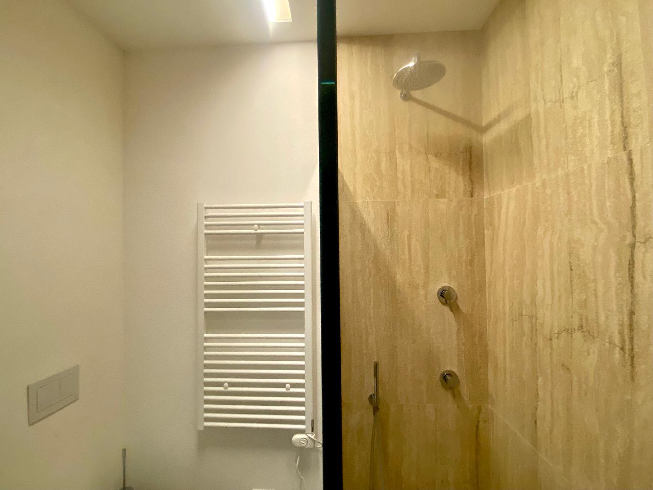 Modern interiors of the bathroom with shower in Aurea apartment, Ortigia