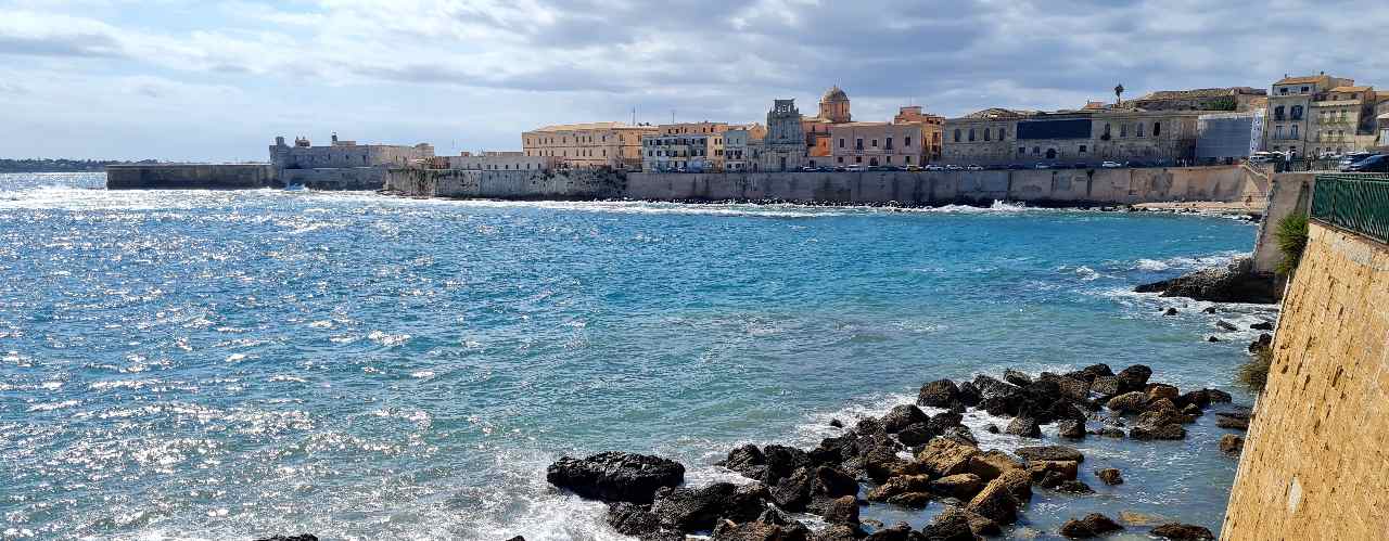 La spiaggia di Calarossa con bagnanti a Ortigia, Siracusa